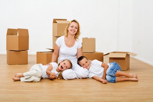 Professional movers carrying household furniture through a Roehampton property